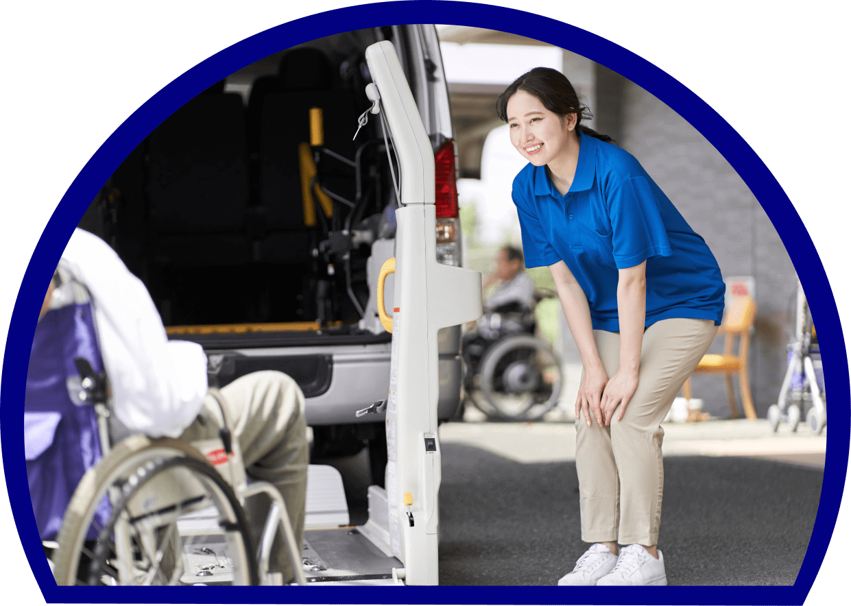 Caregiver assisting person into wheelchair-accessible vehicle.