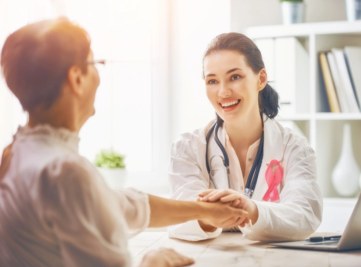 Doctor comforting patient with pink ribbon.
